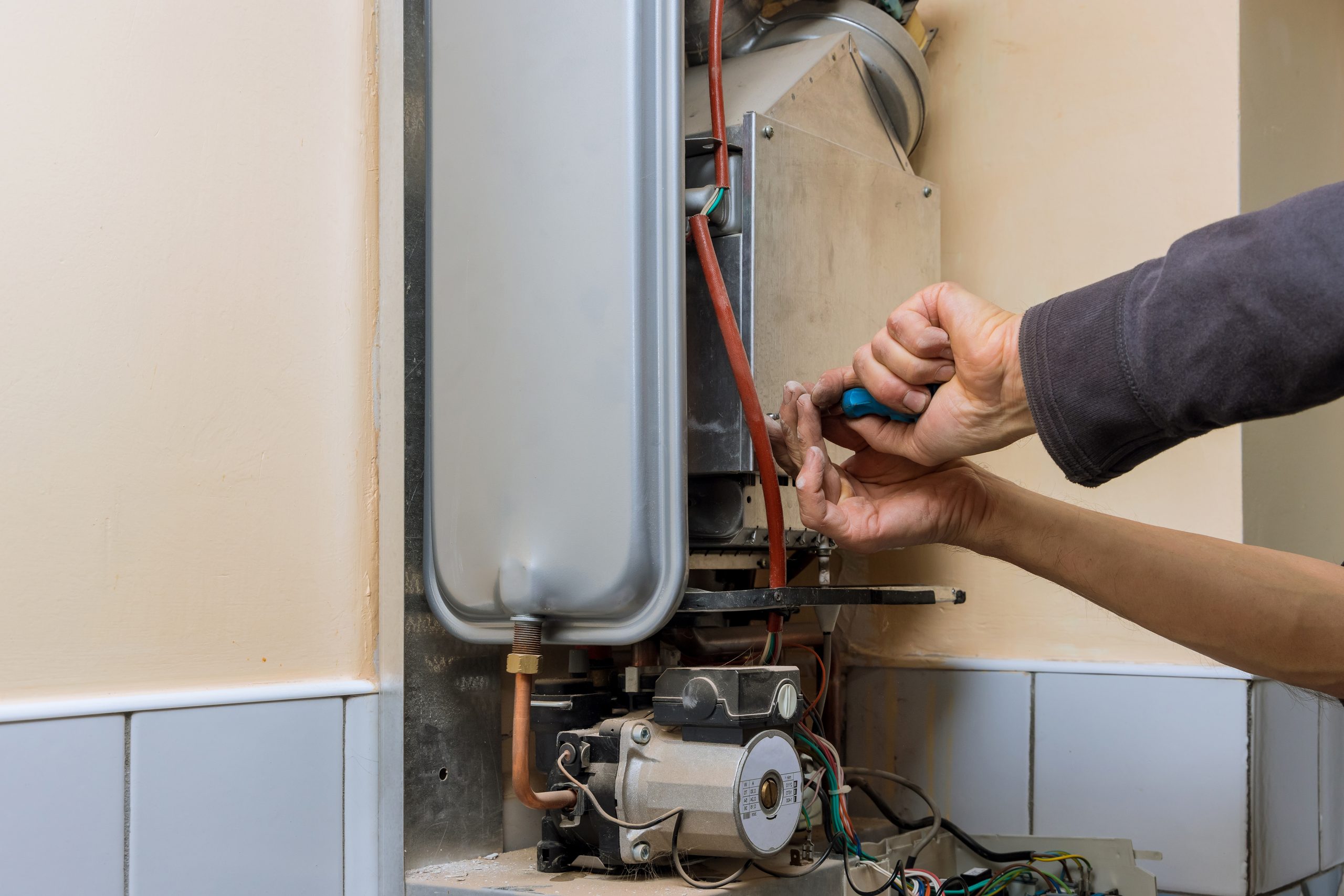 Professional plumber fixing a malfunctioning water heater.