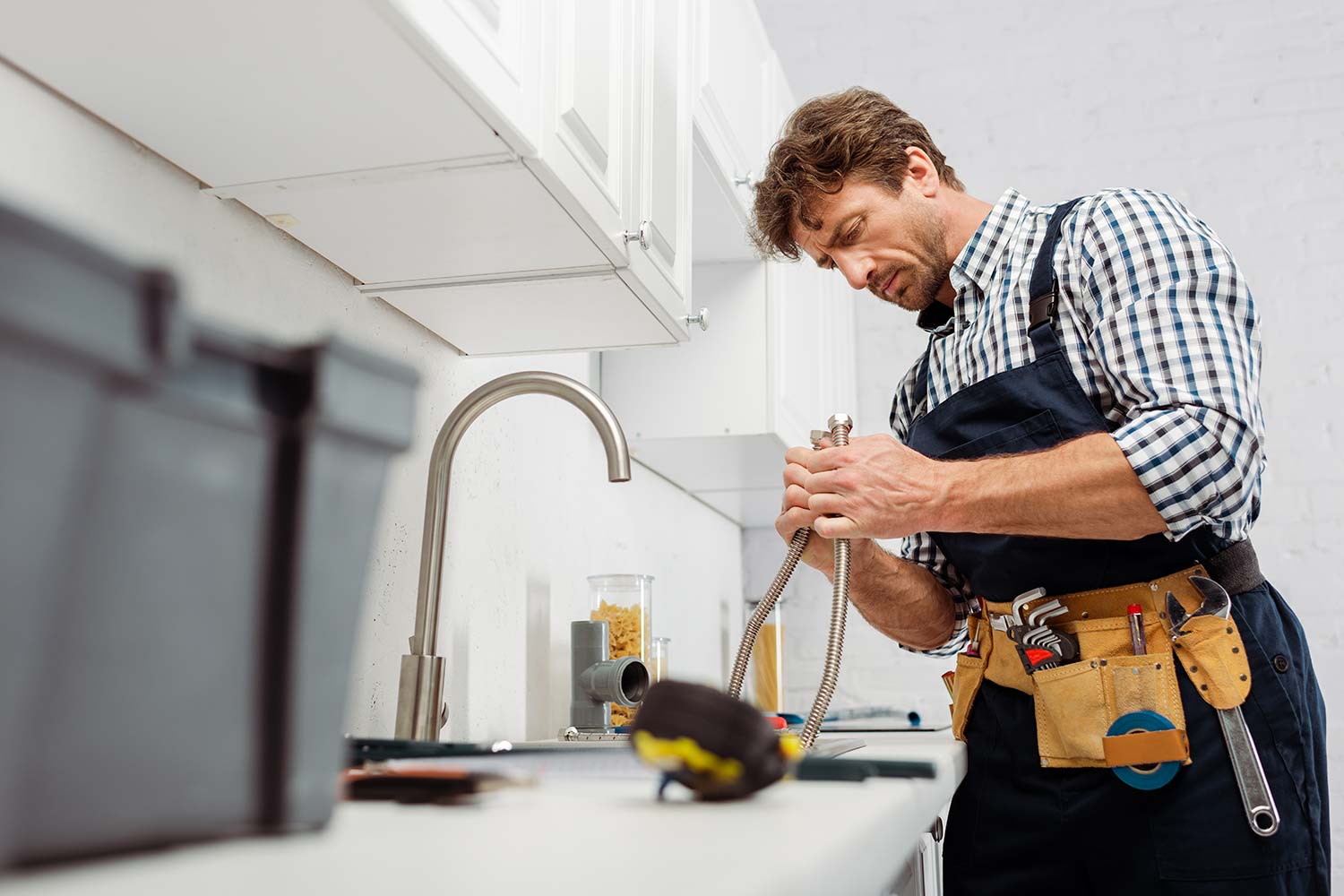 plumber with a hose fixing sink