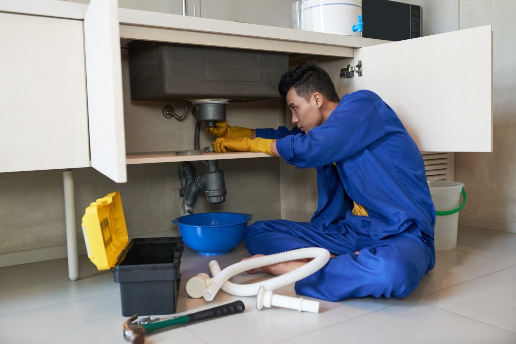  Professional plumber clearing a drain pipe