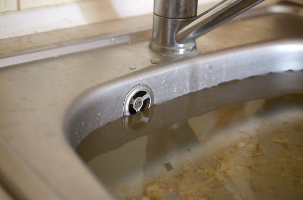 Commercial kitchen drain clogged with food particles