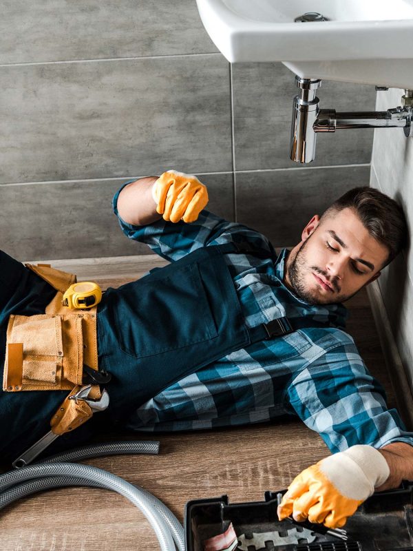 a handyman lying with a tool box beside