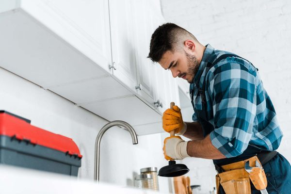 a plumber cleaning the draining pipe